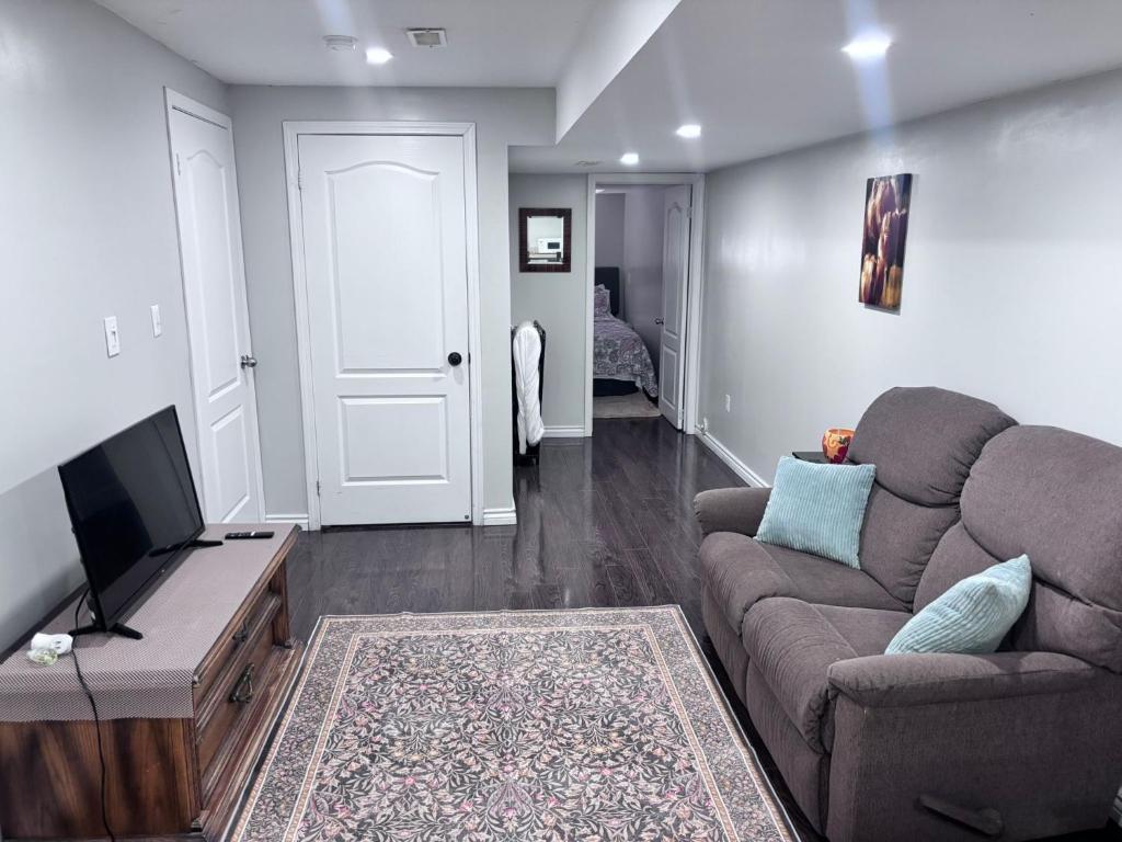 a living room with a couch and a flat screen tv at Bernie's Basement in Milton
