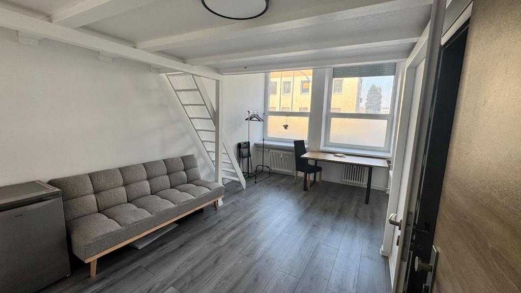 a couch in a room with a desk and a window at atelier in Bratislava