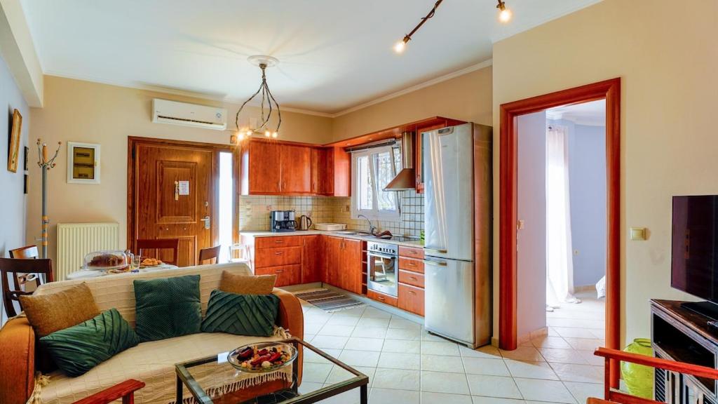 a living room with a couch and a kitchen at Filoxenia in Alepou