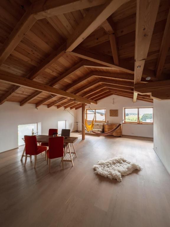 a living room with a table and chairs and a room with windows at Scheune am Bio-Bauernhof in Sankt Georgen bei Salzburg