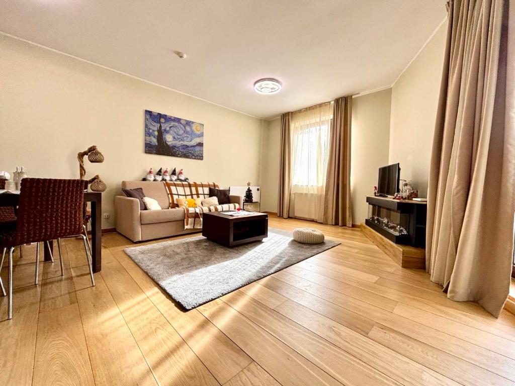a living room with a couch and a table at Alpine Charm Borovets Apart in Borovets