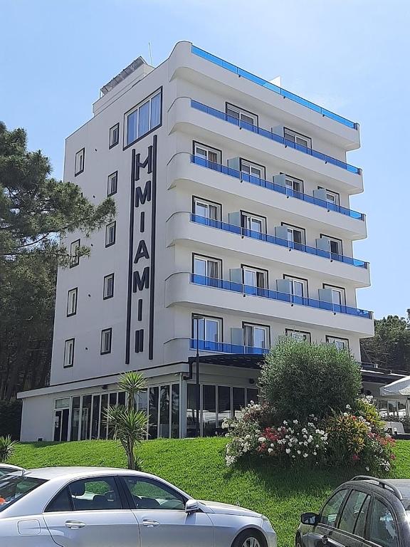 a white building with cars parked in front of it at Hotel Miami II in Golem