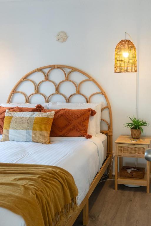 a bedroom with a large bed with a wooden headboard at Oceanview Beach Shack with Pool & Walk to Dining in Aldinga Beach