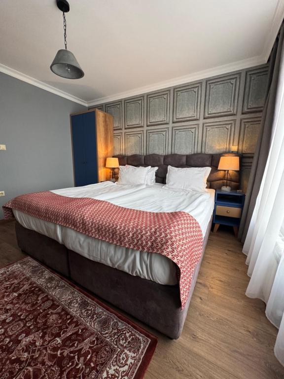 a bedroom with a large bed with two lamps and a rug at Avenue Aparthotel in Sofia