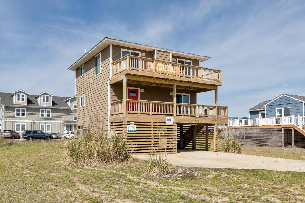 a large house with a balcony and a yard at 4740 - August's Summer Place in Kitty Hawk Beach