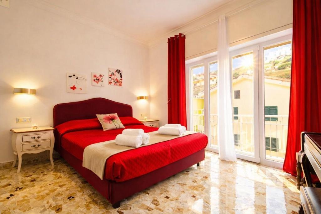 a bedroom with a red bed and a large window at Floral Holiday in Minori