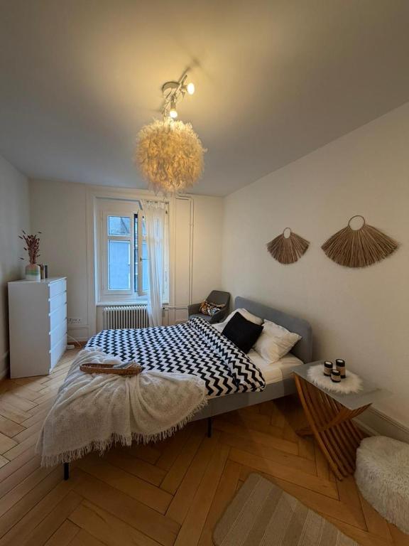 a bedroom with a bed and a chandelier at Central Cozy Rooms in Zurich