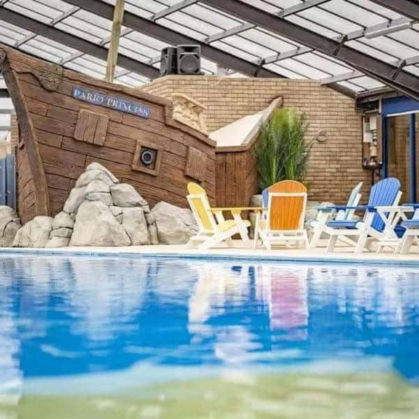 a group of chairs sitting next to a swimming pool at J&A Caravan in Rhyl