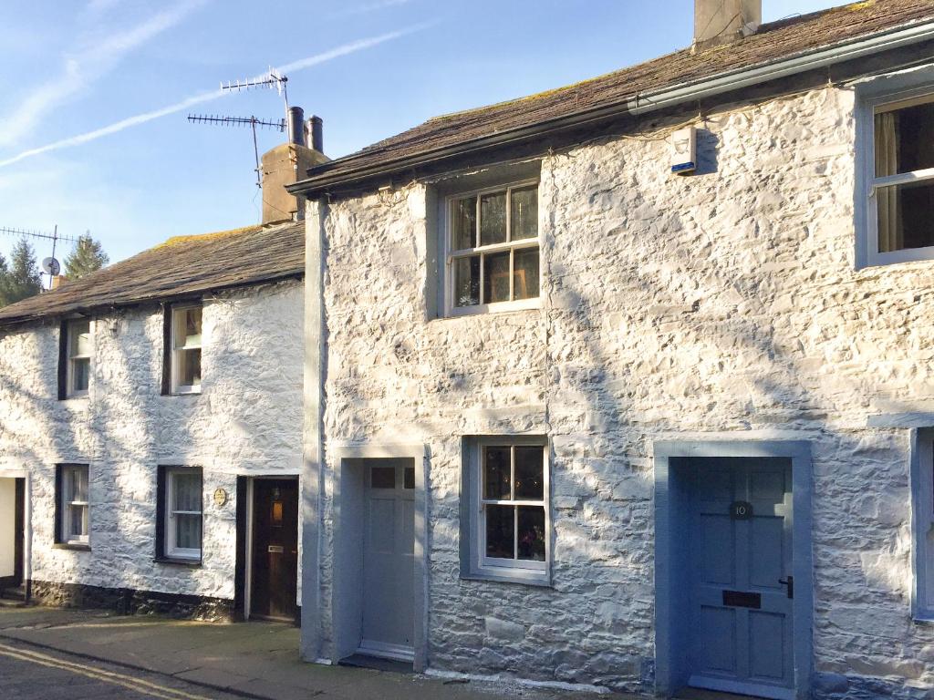an old stone house with blue doors on a street at 11 The Plosh in Keswick