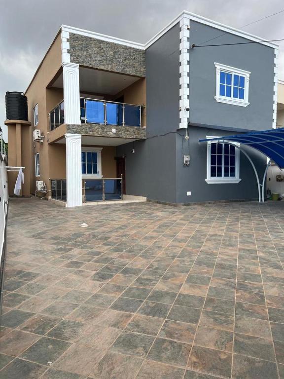 a large house with a large patio in front of it at Chameleon Luxury Apartment in Trofwi
