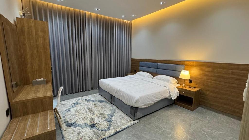 a bedroom with a large bed and a nightstand and a bed sidx sidx sidx at The Queen Apartment in Jeddah