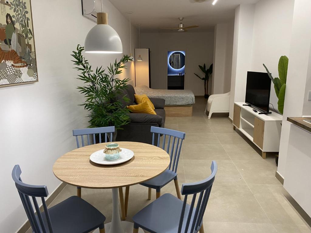 a dining room and living room with a table and chairs at Santa Pola Suites - Self Check-in near Beach in Santa Pola