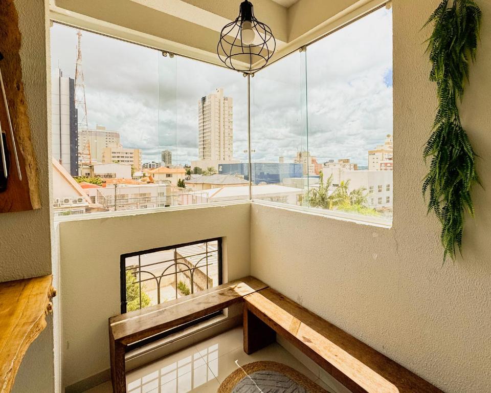 a room with a view of a city from a window at Apê Família | Varanda c/ churrasqueira | Garagem in Ponta Grossa