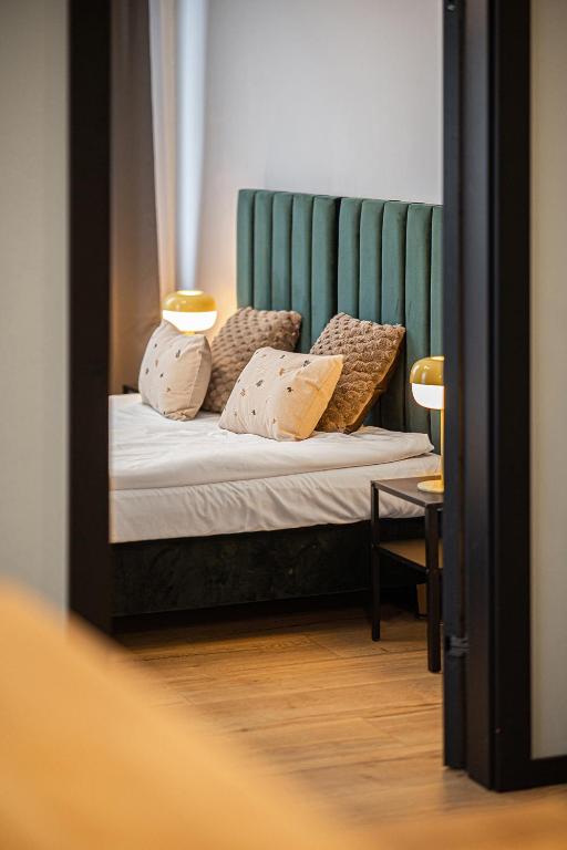 a bedroom with a bed with a green headboard at SECOND HOME Lubawa - 3 pokoje, 5 łóżek, Netflix i Max, parking, winda in Lubawa