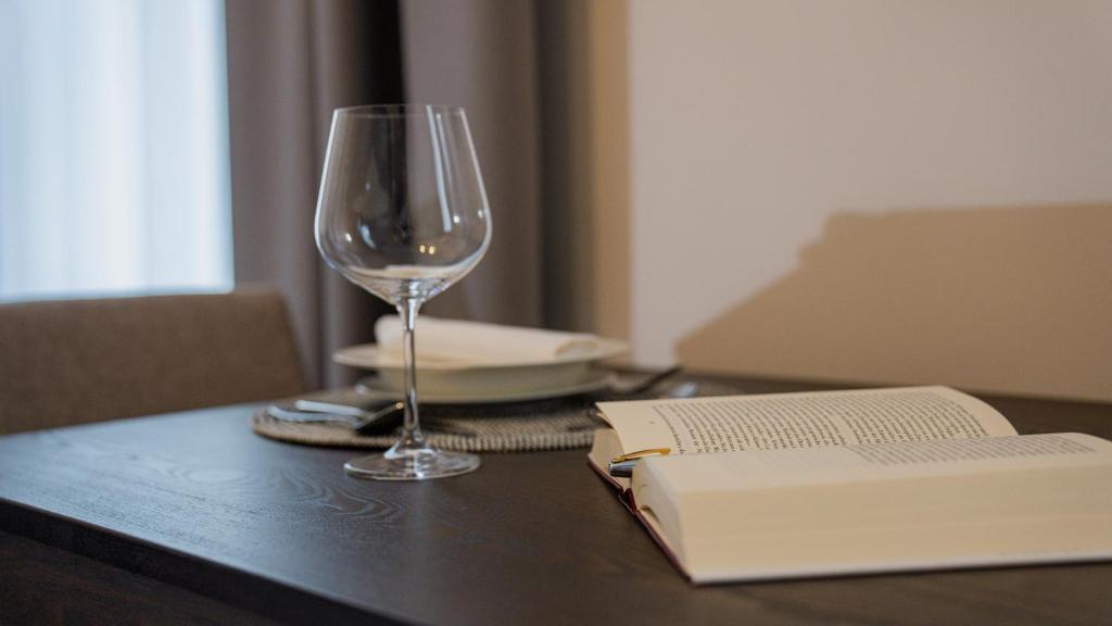 a wine glass and a book on a table at Modernes Studio im Zentrum mit Parkplatz in Gummersbach