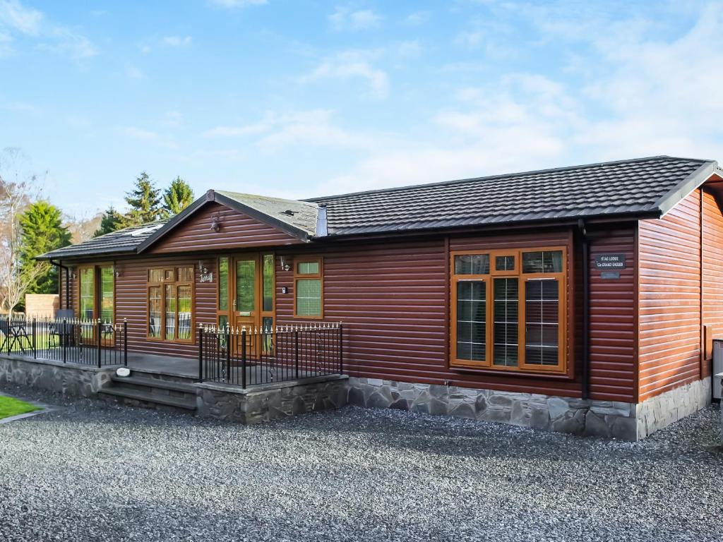 a small wooden house with a lot of windows at Stag Lodge in Auchterarder