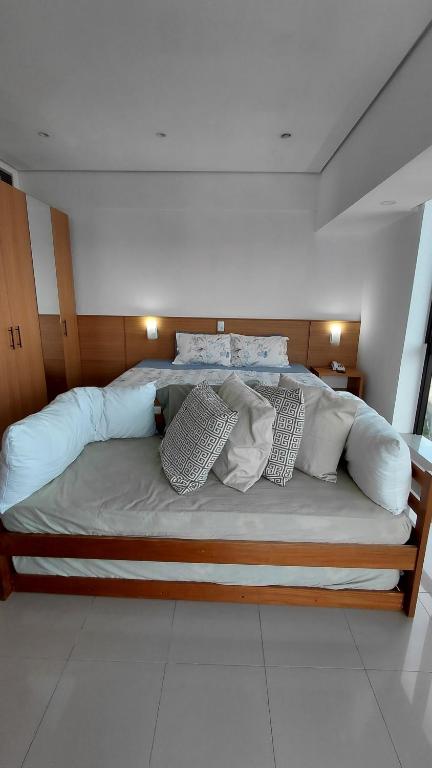 a large bed with pillows on it in a room at Tropical Executive Hotel Flat 205 in Manaus
