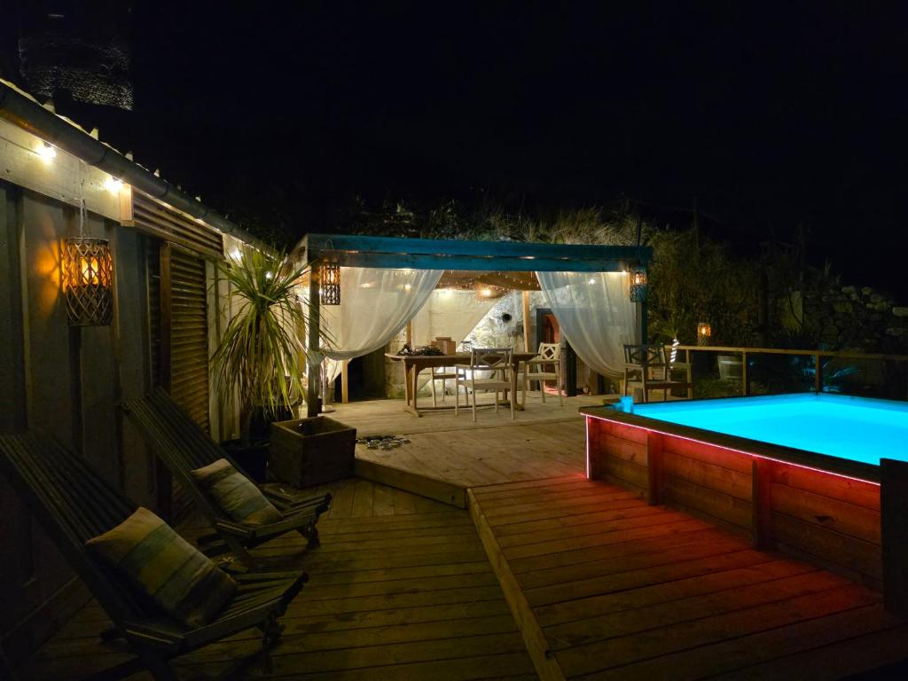 a swimming pool at night with a deck and chairs at Le Tunnel du Moulin in Noyers-sur-Cher