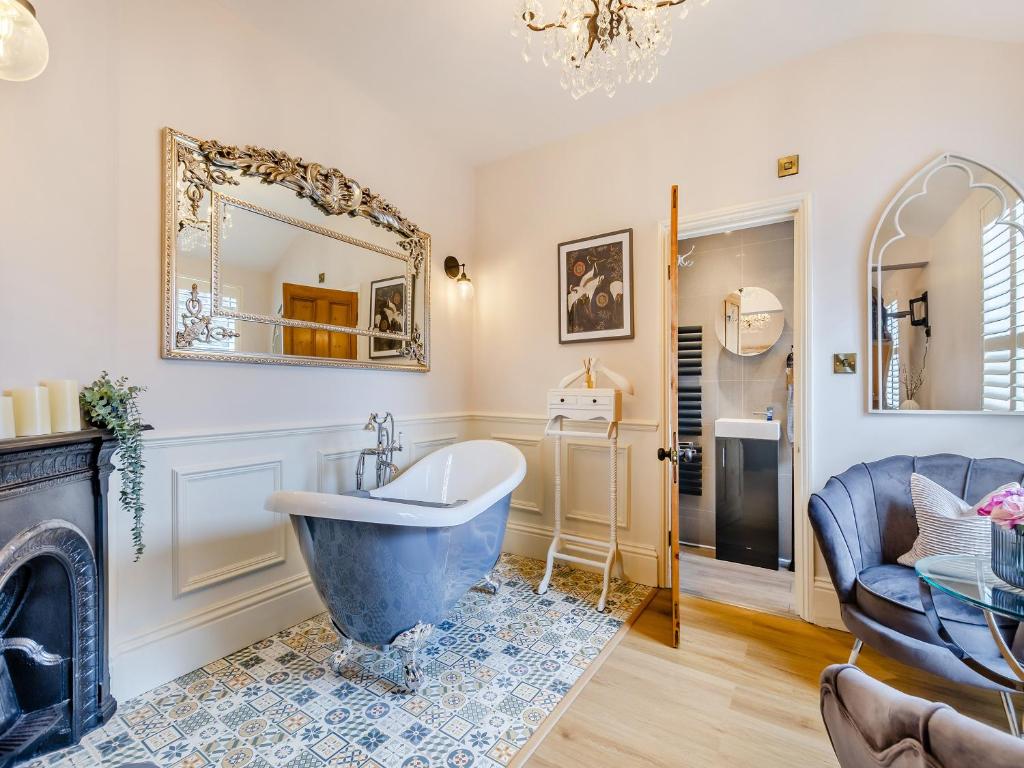 a bathroom with a tub and a fireplace at Jorvik Villas in York