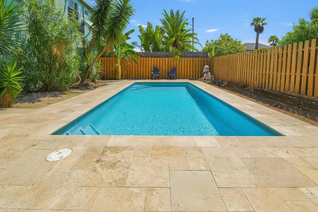 a swimming pool in a backyard with a fence at Bay View Great Deck Pool 2 levels & 3 bedr condo in South Padre Island