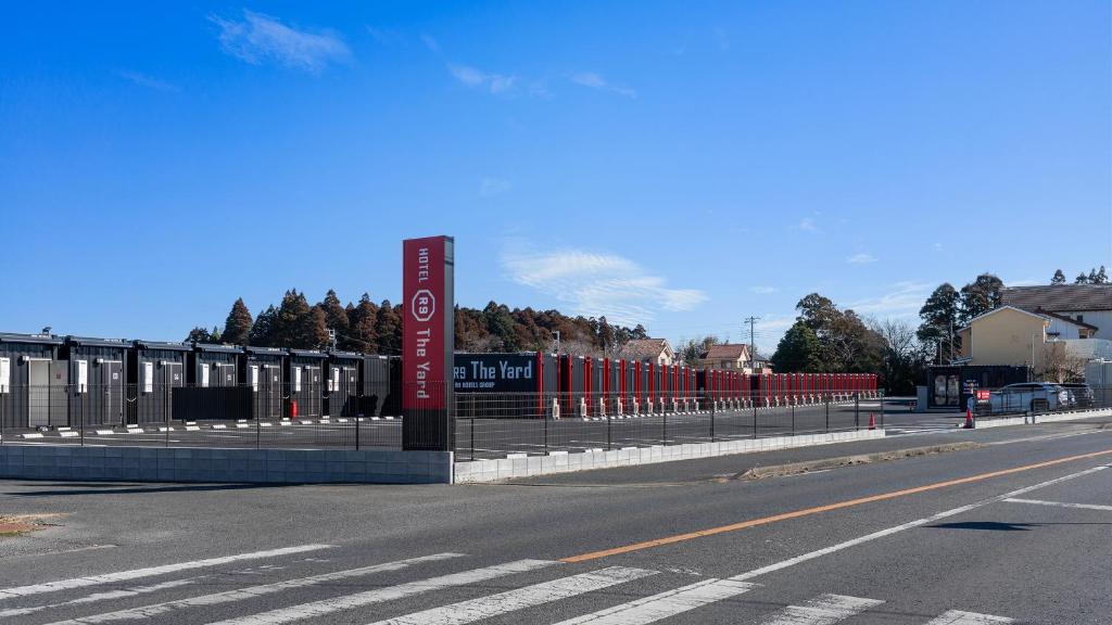 an empty street with a fence and a road at HOTEL R9 The Yard Mobaramutsuno in Machibo