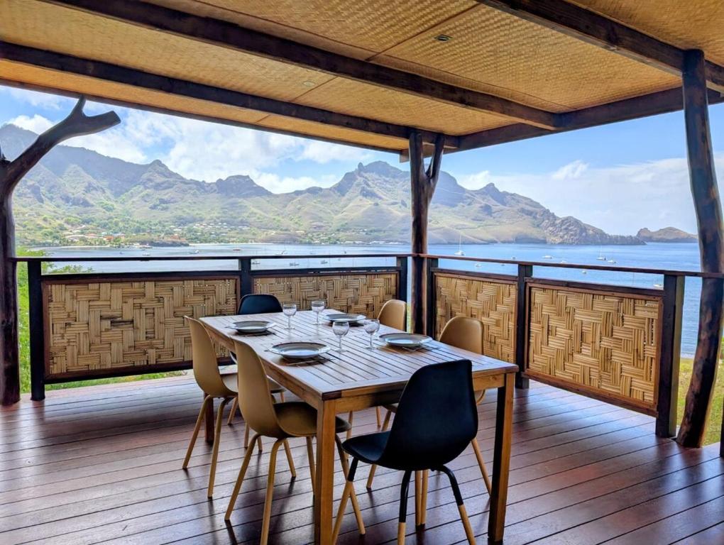 a table on a deck with a view of the mountains at ManaHenua Lodge in Nuku Hiva