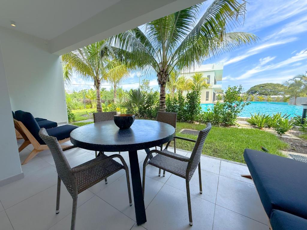 a table and chairs on a patio with a view of the ocean at Ki Resort Apartments & Penthouses by LOV Mauritius in Grand-Baie