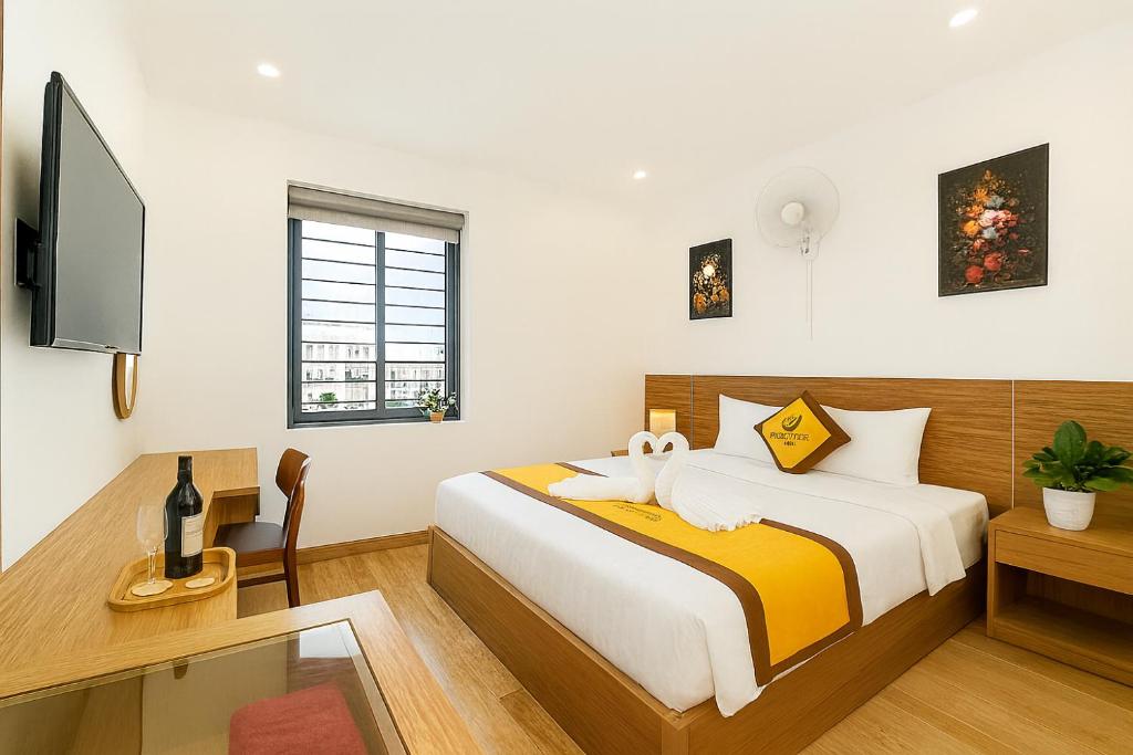 a bedroom with a bed and a desk and a tv at Sonne Hotel Quang Binh in Dong Hoi
