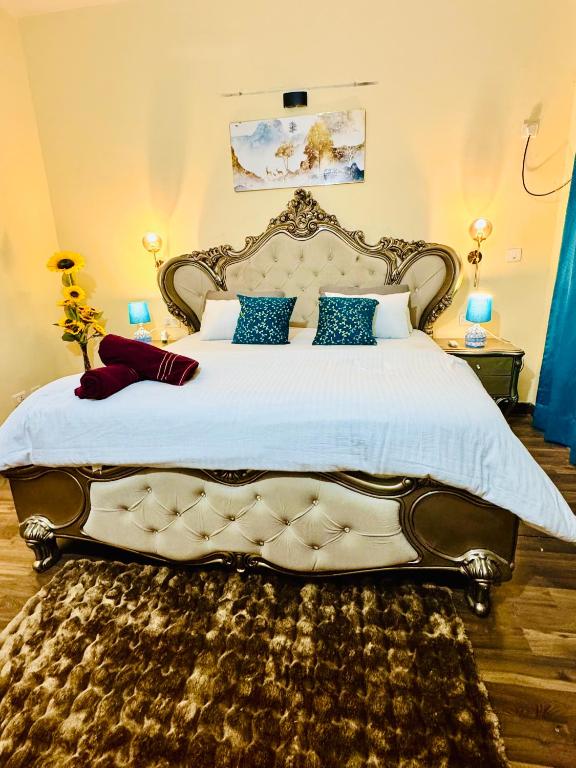 a bedroom with a large white bed with blue pillows at Celebirity garden 4 bhk -5 Bed Lulu and plassio mall gomti nagar in Lucknow