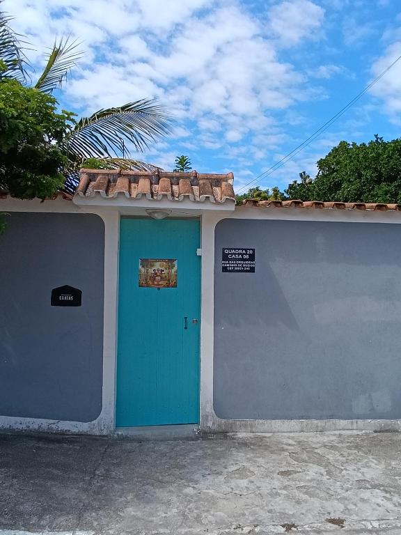 a building with a blue door and a wall at Cantinho da vovó Sol in Cabo Frio