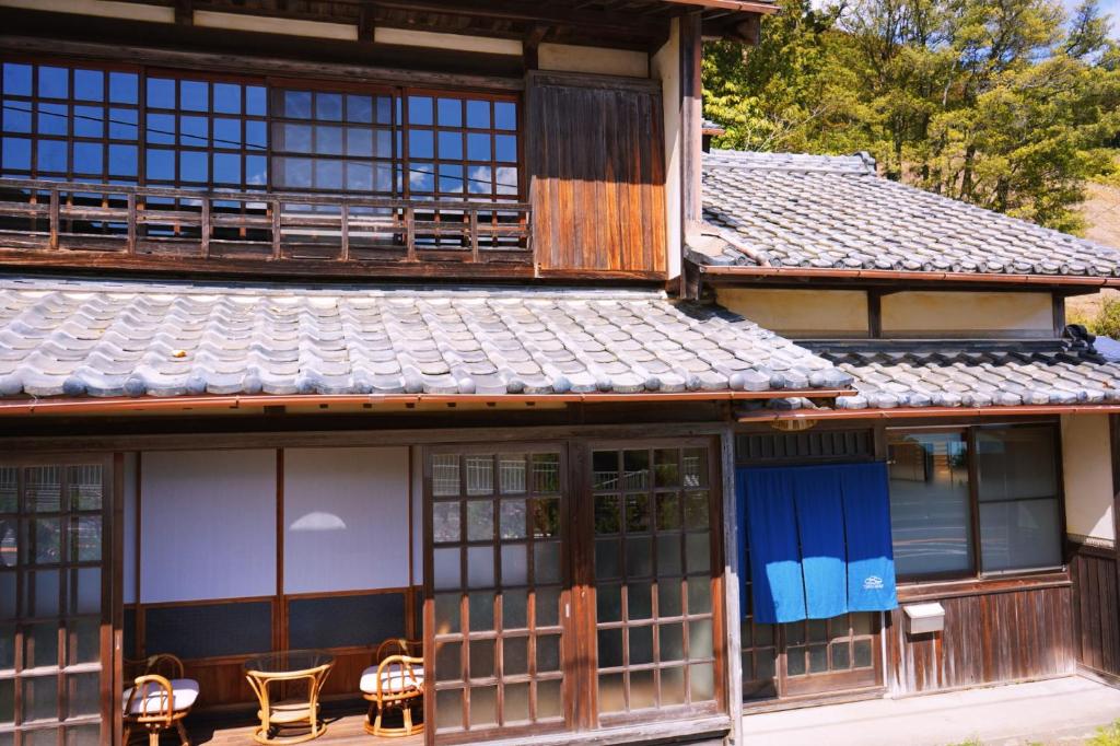 a building with chairs and tables in front of it at Tasogare in Kihokucho