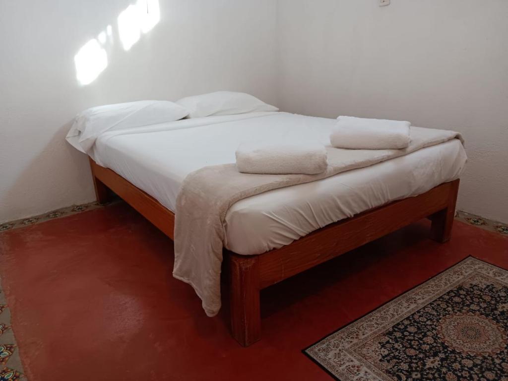 a bed with two white pillows on top of it at Casa Tzipora in Brisas de Zicatela