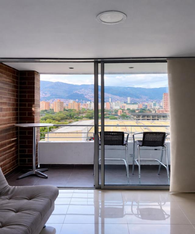 a living room with a balcony with a view of the city at Hotel Ivanna - Laureles in Medellín