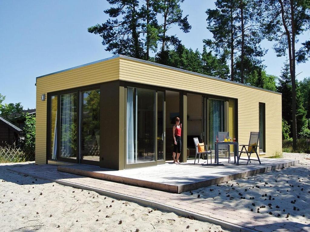 a woman standing outside of a tiny house at Bernsteinsee Homes and Ferien Beach House in Sassenburg
