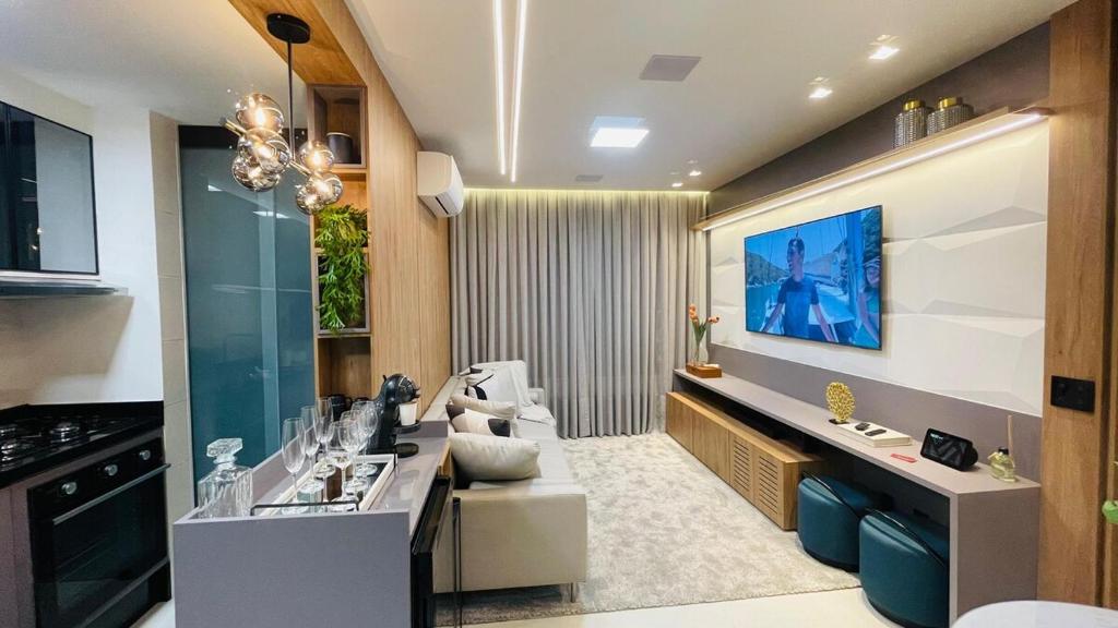 a kitchen with a living room with a tv on the wall at Studio home office Inteligente Com Alexa no Coração do Shopping in Mogi das Cruzes