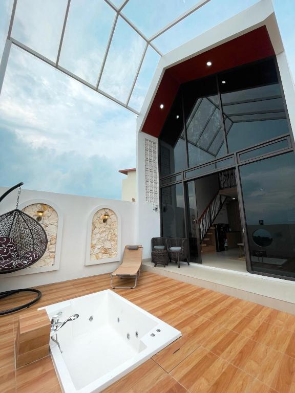 a large room with a white tub and a glass ceiling at Villa with Jacuzzi, Damar Ningrum 4 in Tutugan