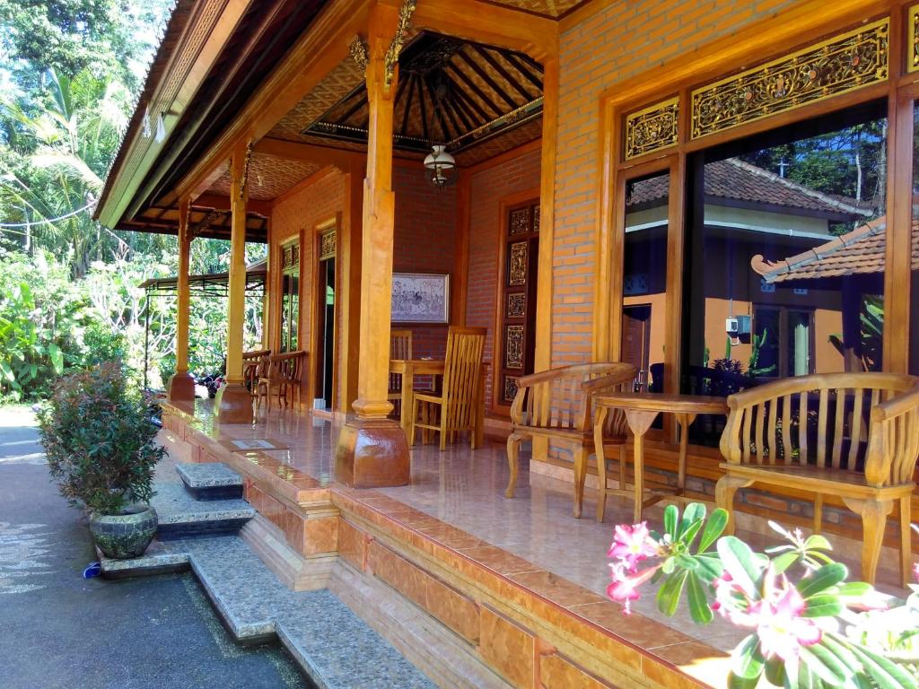 un portico di una casa con tavoli e sedie di Rusma House Ubud ad Ubud