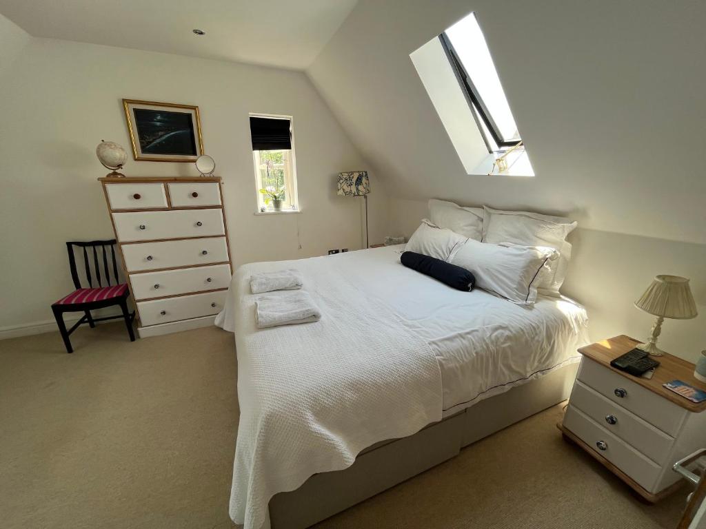 a bedroom with a white bed and a dresser at Silsoe B&B Master Suite in Silsoe