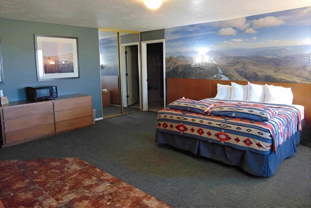 a hotel room with a bed with a painting on the wall at Bryce Canyon Resort in Bryce Canyon