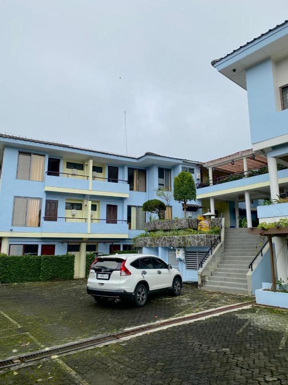 a car parked in a parking lot in front of a building at Kencana INN in Bandungan