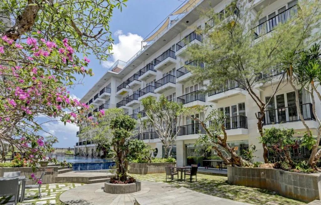 an apartment building with trees in front of it at New Jimbaran Hotel in Ungasan
