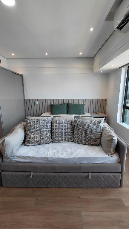a couch in a room with pillows on it at Tropical Executive Suite Flat 1001 Veiw in Manaus