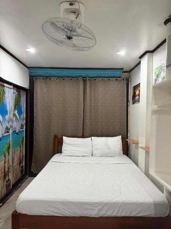 a bedroom with a large bed with a chandelier at Couple Room by Burication Homestay in General Luna