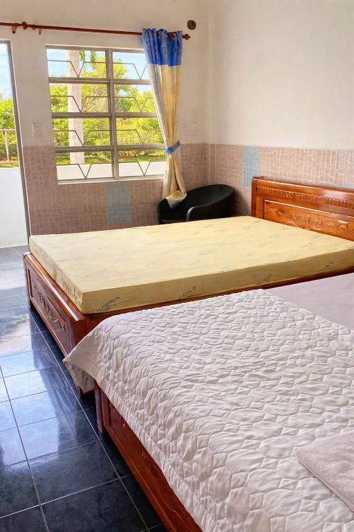 a bedroom with two beds and a window at Thanh Bình Motel Bến Tre in Ben Tre