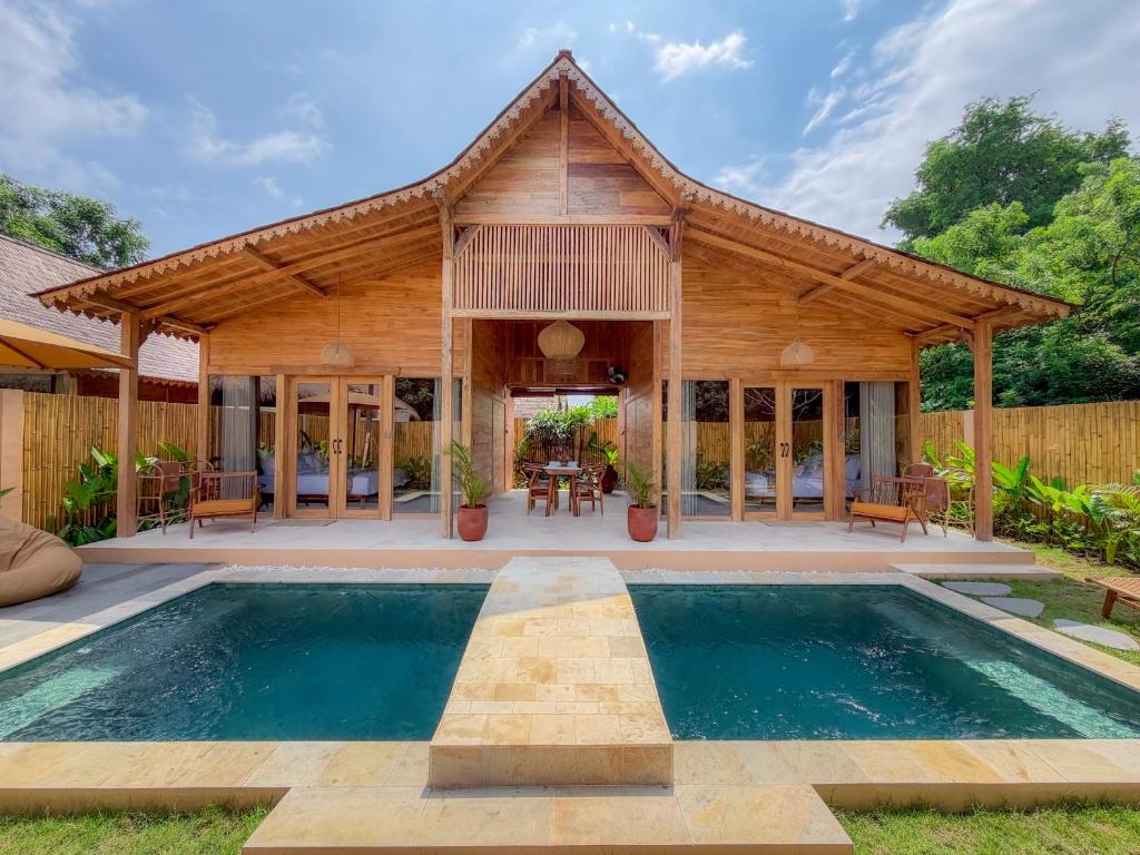 an exterior view of a house with a swimming pool at Taman Jati in Gili Islands