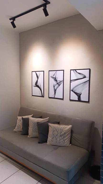 a room with a couch with four pictures on the wall at Apartamento 2QTS aconchegante in Vila Velha