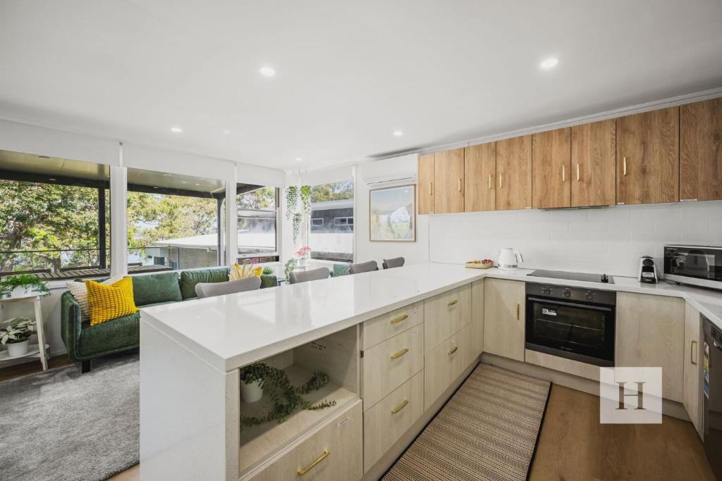 a kitchen with white countertops and a living room at Sunset Shore Retreat in Summerland Point