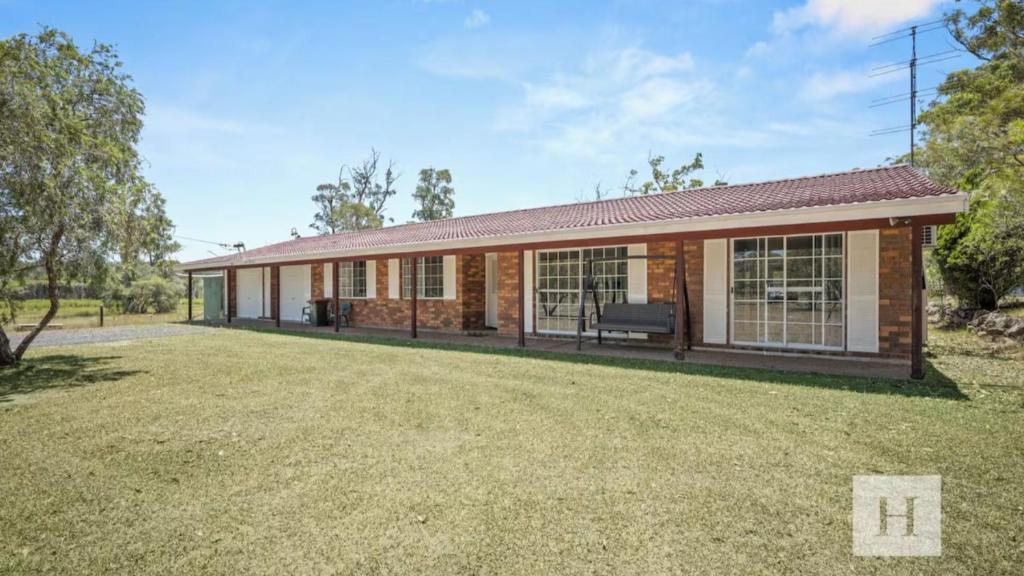 a brick house with a large yard in front of it at Jilliby Honey Farm in Jilliby