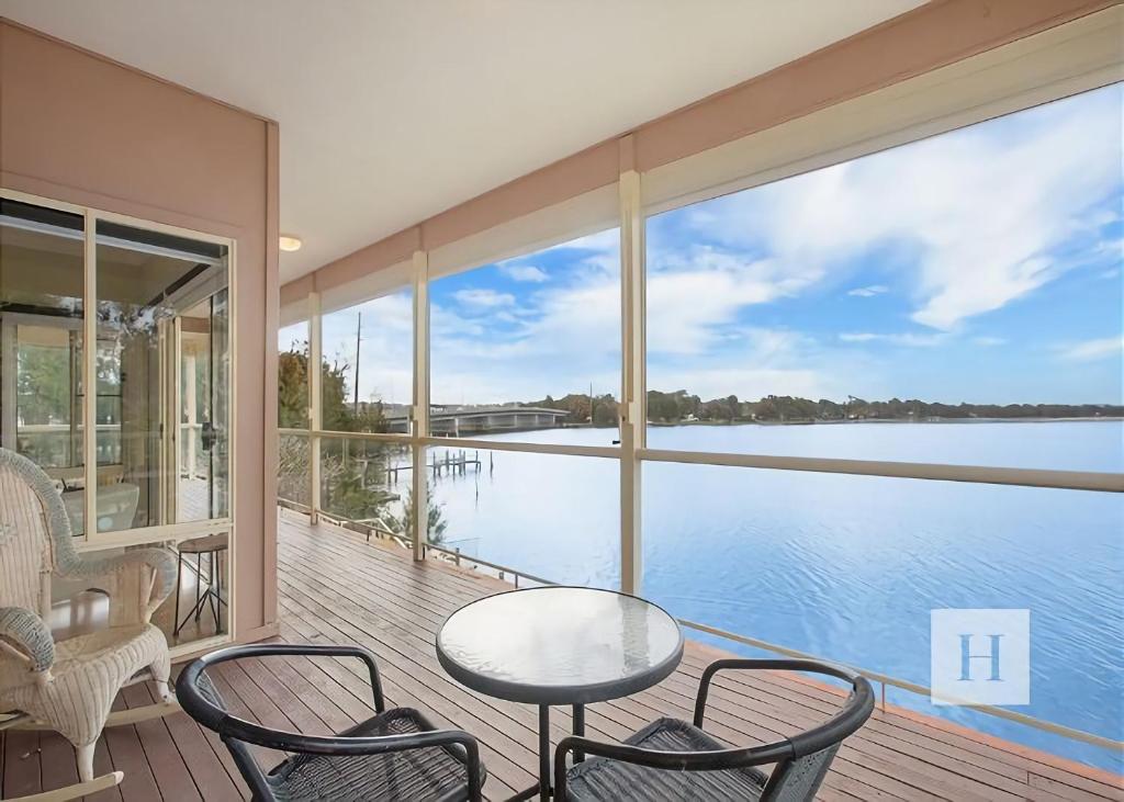 a balcony with a table and chairs and a view of the water at Tide view in Toukley
