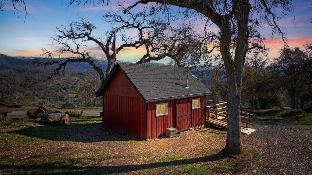 a small red shed sitting next to a tree at Valley View Hideaway Cabin with Mountain Views in Miramonte